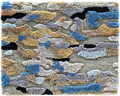 Luxury designer rug in a blue, grey, tan, and beige camouflage pattern with tufted texture.