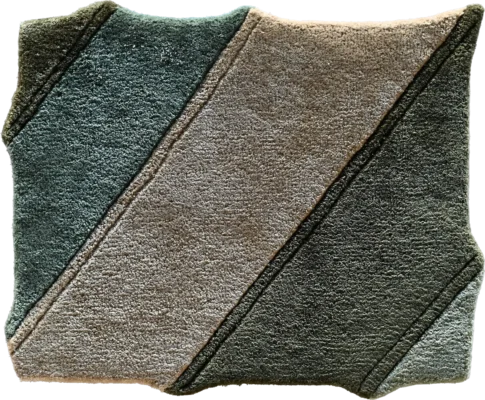 A folded towel shows designer rug-inspired diagonal blocks, ideal for luxury custom rugs décor.