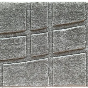 Luxury designer rug in gray with a raised geometric pattern, modern and high-end.