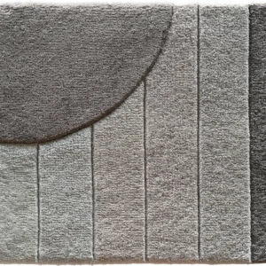 Luxury designer rug in gray tones with vertical blocks and a bold dark semicircle.