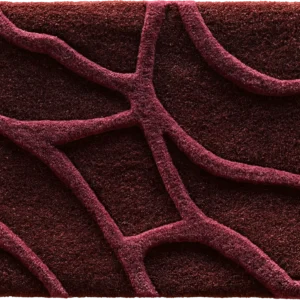 A close-up of a luxury designer rug featuring dark red textured waves in an irregular high-end pattern.