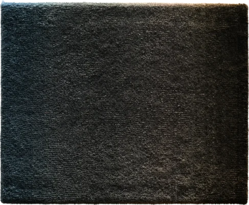 A rectangular luxury designer rug in dark gray, featuring a dense, high-end textured surface.