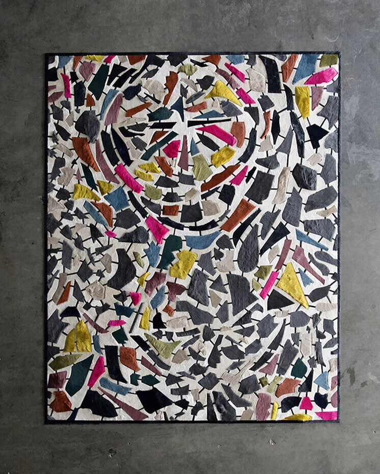 Luxury designer rug with colorful abstract patterns on concrete floor, handmade wool.