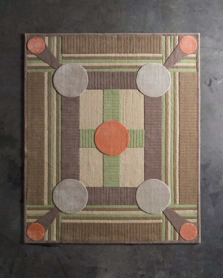 Luxury designer rug with geometric earthy shapes, handmade wool on a dark gray floor.