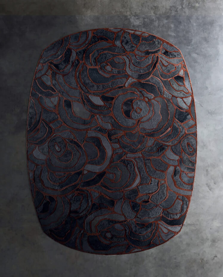 Luxury designer rug with abstract floral pattern, handmade in silk and wool, on concrete floor.