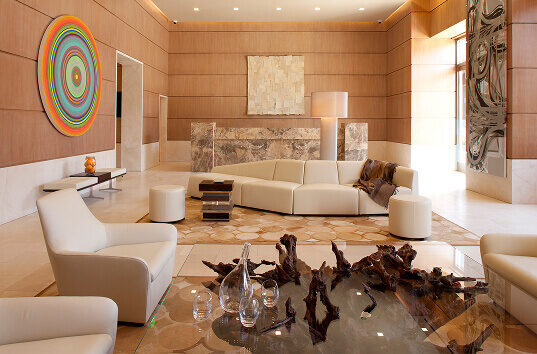 A living room featuring a couch, glass table, and a luxury designer wool rug.