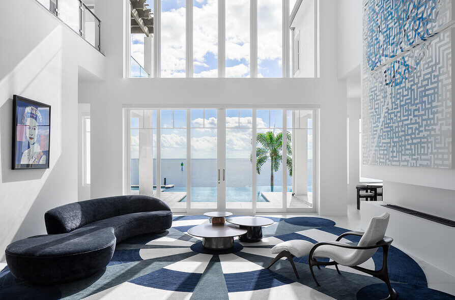 Modern living room featuring a handmade luxury designer rug, pool view, ocean backdrop, and contemporary décor.