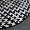Close-up of the Blackdog Hide 14697 high-end designer round rug with bold black and white handmade hide pattern on concrete.
