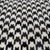 Close-up of Blackdog Hide 14697, a high end designer rug with a black and white houndstooth pattern and luxe textured finish.