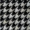 Close-up of Blackdog Hide 14697, a luxury designer rug with black and white houndstooth, handmade hide texture.