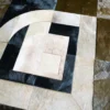 Luxury designer rug featuring handmade hide squares and curves in beige, black, and brown.