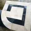 A close-up of the Prisma luxury designer rug with geometric black, white, and beige shapes.