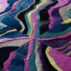 The Submerge Hide 14897 is a luxury designer rug with vibrant wavy multicolor patterns.