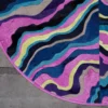 Close-up of a luxury designer round rug with wavy patterns, handmade from high quality hide.