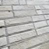 Close-up of a wall with staggered, white fur tiles resembling luxury designer hide rugs.