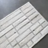 A luxury designer Beltway Hide 25131 rug with a geometric pattern sits on a sleek grey floor.