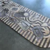 The Mika Hide 29748 is a luxury designer rug with geometric patterns in gray and beige.