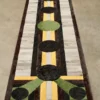 Luxury designer rug with geometric circles and stripes in bold hues on concrete floor.