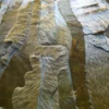 Close-up of luxury handmade hide rug shows stitched pieces with varied fur textures and colors.
