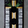 Luxury designer rectangular rug with geometric patterns and large black circles on a gray floor.