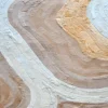 Luxury designer rug with abstract wavy layers in beige, cream, and pale yellow tones.