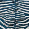 Close-up of luxury designer rug in blue and white stripes, resembling stylized zebra hide.