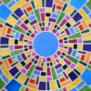 High end designer rug featuring a circular mosaic of vibrant geometric rings on gray.