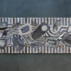 Rectangular luxury designer rug with rounded edges, layered geometric shapes, and textured gray, black, and beige pattern.