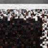 Close-up of a luxury designer rug with a mosaic gradient of brown, black, and white squares.