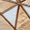 Luxury designer rug featuring intersecting brown lines over textured beige, tan, and white hide.
