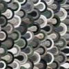 Luxury designer rug featuring interlocking semicircles in green, gray, beige, and black with a textured, high-end finish.