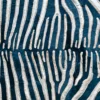 Luxury designer rug close-up: cream wavy lines on textured dark teal evoke handmade hide rugs.
