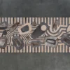 Luxury designer rug features abstract stone motifs on bold striped handmade hide.