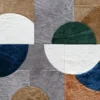 Abstract luxury designer rug featuring blue, green, and neutral textured geometric forms.