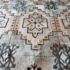 A close-up of Winterlude Hide 26667, a high end designer rug with geometric, snowflake motifs in neutral hues.