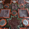 Close-up of high end designer rug fabric in brown and orange, handmade with textured hide.
