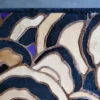 Luxury designer rug with abstract curved beige, black, brown, and purple on grey floor.