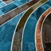 Close-up of Custom Hide 15342, a luxury designer rug with blue, brown, green, and tan geometric curved sections and a high-end textured hide surface.