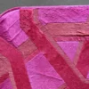 Close-up of Vertigo Hide 15520, a luxury designer geometric pink hide rug with rounded corners on gray floor.