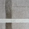 Luxury custom designer rug in beige and brown wool and silk with grid pattern and intersecting stripes.