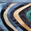 The Drift Hide 29332 luxury designer rug features multicolored curved stripes on a gray floor.