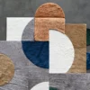 Luxury designer hide rug with layered geometric shapes in premium hues on gray floor.