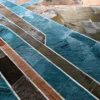 Luxury designer rug with curved teal, brown, and gray bands on a high-end textured surface.