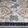 Luxury designer rug with beige and brown star motifs on a high-end patchwork background.