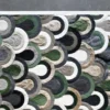 Luxury designer rug featuring green, beige, and gray overlapping circles on a gray floor.
