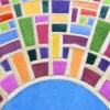 Close-up of luxury designer rug Tower Hide 15599, with a circular mosaic in multicolored handmade hide and silk.