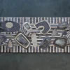 Luxury designer rug with abstract geometric relief in gray, black, and beige tones.