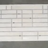 The Beltway Hide 25131 luxury designer rug with cream, white, and gray geometric rectangles on a concrete floor.