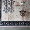 Close-up of Winterlude Hide 26667, a high-end handmade designer rug with fur texture and geometric patterns in black, gray, and brown.