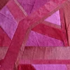 Vertigo Hide 15520, a high-end designer rug, showcases a pink-red geometric motif and luxe textured hide.